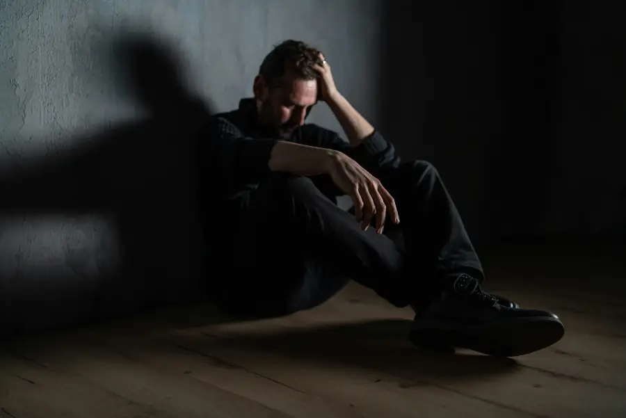 Mann sitzt allein und ersch&ouml;pft am Boden &ndash; sie hat keine Gef&uuml;hle mehr